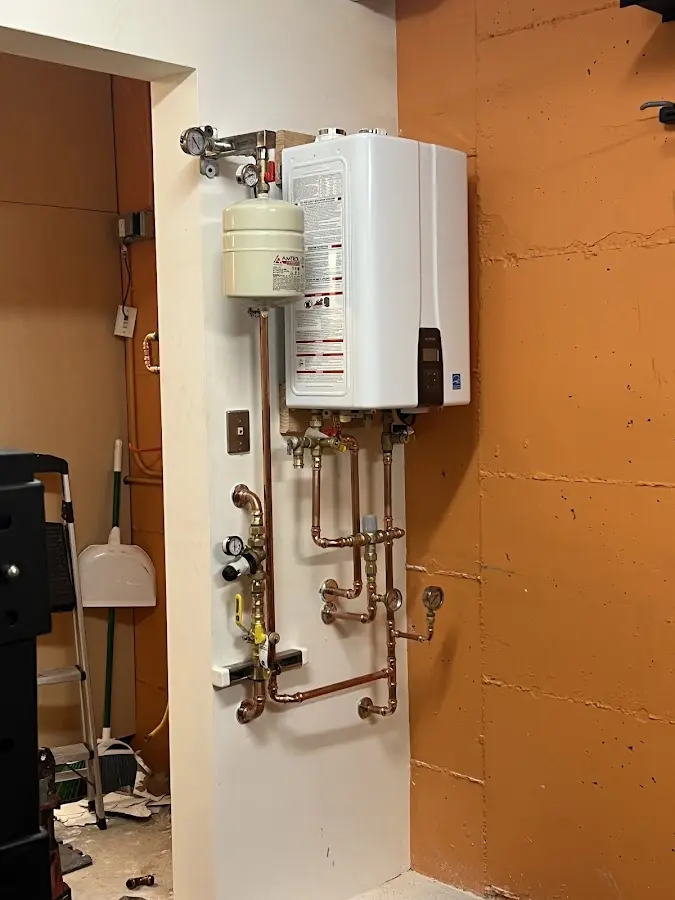 Plumbing technician inspecting water heater connections in Wausau